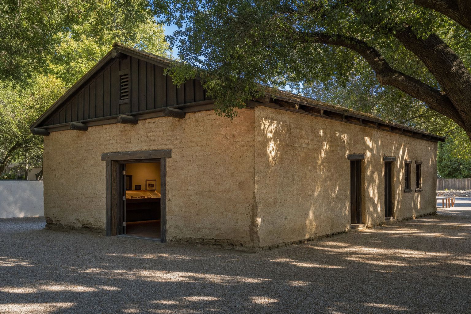 A restored 1850s adobe fort building in Sacramento with mature shade trees
