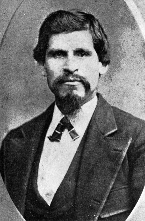 Black-and-white 1874 studio portrait photograph of Tiburcio Vásquez, a bearded man in a suit and bow tie